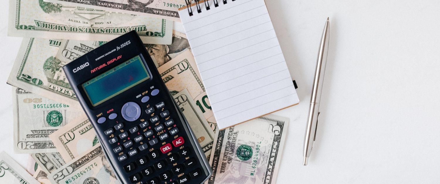 Calculator resting on U.S. cash — tax preparation at EasyTax Plus in Etowah, TN